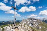 Gipfelkreuz der Krähe mit der Ammergauer Hochplatte im Hintergrund