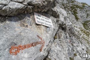 Der Einstieg aus dem Gimpelkar in die Felsroute ist mit einem roten Pfeil und einem Schild markiert
